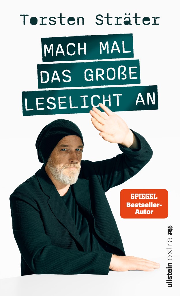 Cover von „Mach mal das große Leselicht an“: bärtiger Mann mit Beanie hebt Arm, weißer Hintergrund, Titel in grünen Balken.